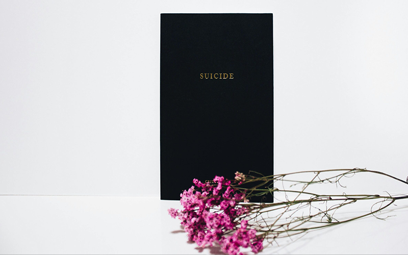 A compassionate hand holding a phone displaying key mental health helpline numbers Suicide Crisis Helpline and Kids Help Phone.